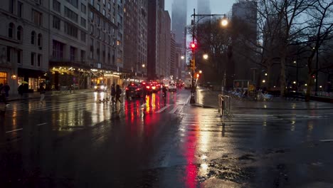 Shot-of-people-crossing-over-the-crosswalks-at-59th-Street,-Central-Park-and-6th-Avenue-during-a-rainy-afternoon-in-New-York-City