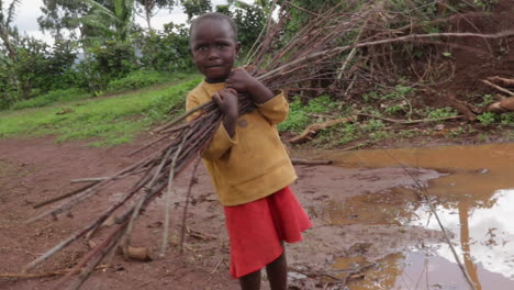 young-children-kid-carrying-wood-walking-alone-on-forest-path-after-storm-rain-in-remote-rural-village
