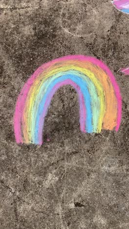 Vertical-footage-of-colorful-chalk-rainbow-on-sidewalk,-cute-symbol