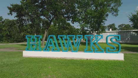 A-zooming-out-dolly-shot-of-the-University-of-Houston-Clear-Lake-HAWKS-mascot-sign-at-UHCL,-Clear-Lake,-Houston,-Texas