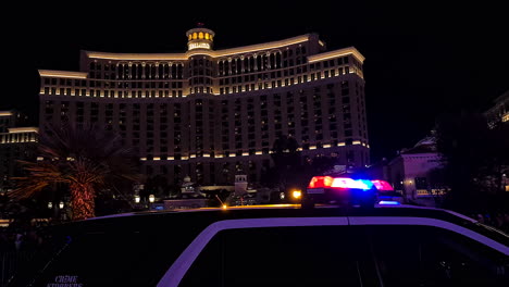 Las-Vegas-Metropolitan-Police-Car-With-Emergency-Lights-at-Night-in-Front-of-Bellagio-Casino-Hotel,-Nevada-USA