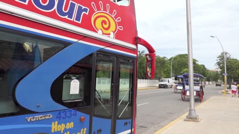 Varadero-Hon-On-Hop-Off-bus-BeachTour-in-Cuba,-arriving-at-stop,-panning-shot