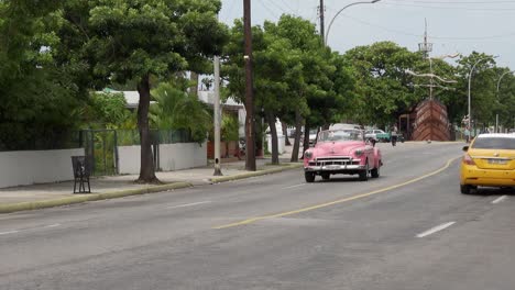 Pink-Chevrolet-DeLuxe-1950-Convertible-vintage-car-in-Varadero,-Cuba,-panning-shot