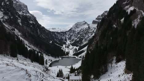 Luftaufnahme-Der-Schneebedeckten-Berge-Rund-Um-Den-Talalpsee-In-Der-Schweiz