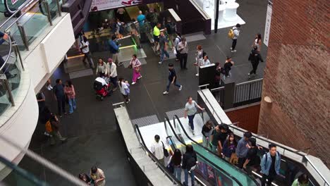 Shoppers-and-daily-commuters-taking-the-escalators-up-and-down-at-Melbourne-Central-Station-during-rush-hour,-a-shopping-and-commercial-precinct-in-downtown,-a-hustle-and-bustle-of-urban-lifestyle