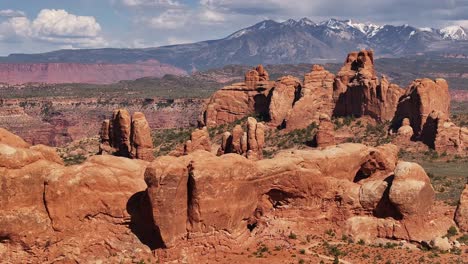 Atemberaubende-Aussicht-Auf-Rote-Felsformationen-In-Moab,-Utah,-Mit-Schneebedeckten-Bergen-Im-Hintergrund