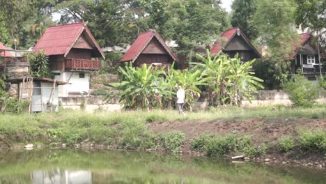 Tourist-walking-among-traditional-Thai-houses-in-Pai,-Thailand