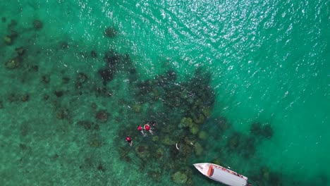 turquoise-water,-lagoon-Beach-on-Besar-Perhentian-island,-tourists-snorkeling