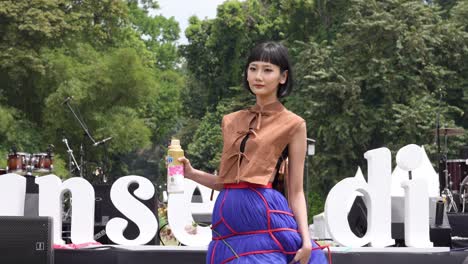 Beautiful-young-fashion-model-promotes-brand-product,-Asian-outdoor-event