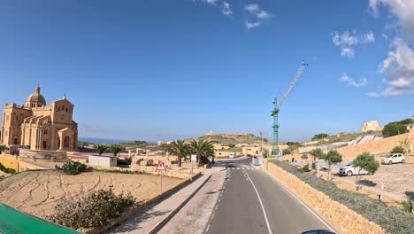 Time-lapse-of-a-journey-on-the-upper-deck-of-a-bus-through-Gozo,-Malta,-passing-by-The-Basilica-of-the-National-Shrine-of-the-Blessed-Virgin-of-Ta'-Pinu,-the-most-famous-Roman-Catholic-basilica