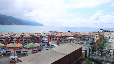 Playa-Llena-De-Gente-En-Monterosso-Al-Mare-Cinque-Terre-Con-Coloridas-Sombrillas-Y-Gente-Disfrutando-Del-Verano