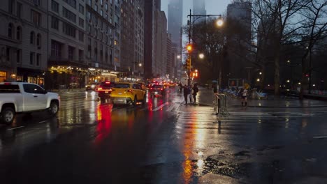 Shot-of-56th-Street-traffic-seen-from-the-Central-Park-sidewalk-during-a-rainy-afternoon-in-New-York-City