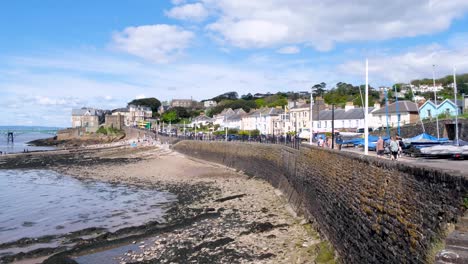 Coastal-view-of-people-visiting-Clevedon-seaside-town-and-walking-along-the-waterfront-overlooking-the-beach-and-Severn-estuary-in-Somerset,-England-UK