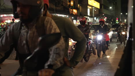 Motorcycles,-CNGs,rickshaws-and-vehicles-pass-by-in-the-diplomatic-Banani-district-at-night-displaying-Dhaka's-various-mehods-of-transportation