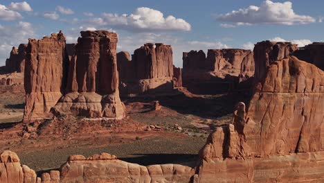 Majestic-red-rock-formations-stand-tall-in-the-dramatic-desert-landscape-of-Moab,-Utah-USA---aerial