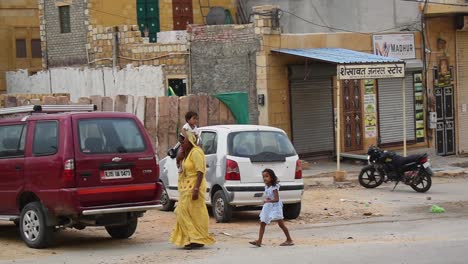 Mother-sits-her-youngest-child-on-her-shoulder-going-for-a-walk-with-both-of-her-children