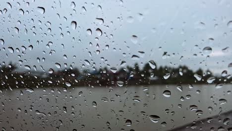 Regentropfen-Auf-Dem-Fenster,-Während-Wasser-Am-Glas-Herunterläuft