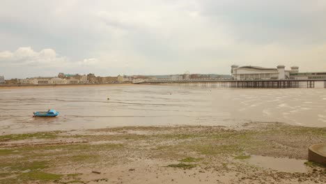 Der-Grand-Pier-In-Weston-Super-Mare-Bei-Ebbe-Mit-Einem-Einsamen-Boot-Am-Schlammigen-Ufer