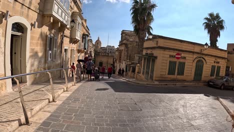 Visitors-and-travelers-move-along-the-tiny-streets-of-Gozo,-Malta,-capturing-the-essence-of-quaint-exploration-and-cultural-charm