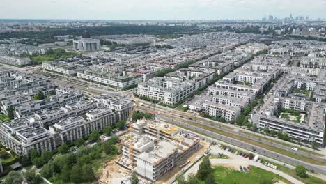 Aerial-top-down-view-on-the-rooftop-of-an-apartment-building-under-construction-with-tower-crane-and-a-lot-of-workers-laying-metal-rebar