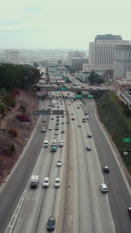 Los-Angeles-USA,-Vertical-Aerial-View-of-US-101-Highway-Traffic-Along-Downtown-Buildings,-Hollywood-Freeway
