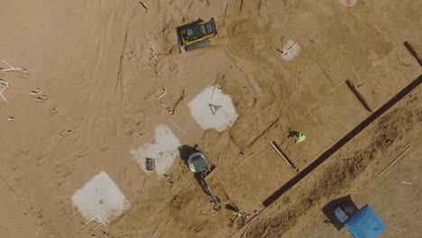 An-aerial-top-down-view-heavy-equipment-operators-working-at-a-new-building-construction-site-in-Clear-Lake,-Houston,-Texas