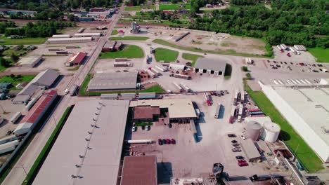 Aerial-view-of-an-industrial-area-with-semi-trucks-on-the-road-and-parked,-Concept-focusing-on-hiring-dry-van-and-reefer-truck-drivers