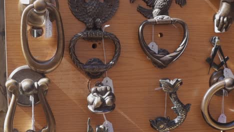 A-tilt-down-close-up-shot-of-a-collection-of-beautiful-door-knockers