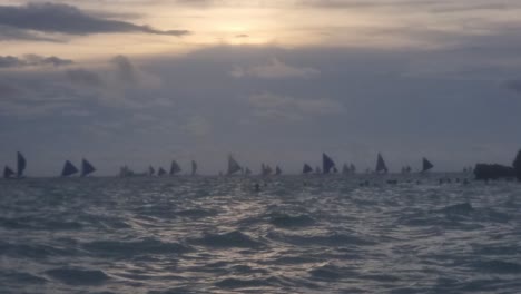 Handheld-shot-of-waves-and-boats-in-the-background-in-Boracay-at-sunset