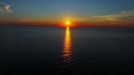 Toma-De-Seguimiento-Aéreo-Sobre-El-Mar,-Calma,-Puesta-De-Sol-De-Verano,-En-Kalajoki,-Finlandia.