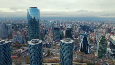 Titanium-tower-and-park,-snowy-Andes-background,-fall-day-in-Chile---Drone-shot