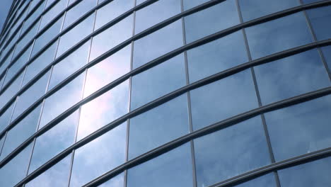 Modern-walls-are-made-of-glass-and-steel-with-reflections-of-buildings,-sunlight-and-sky