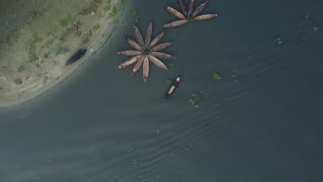 aerial-view-of-wooden-boats,-arranged-in-a-flower-pattern,-floating-on-a-majestic-river
