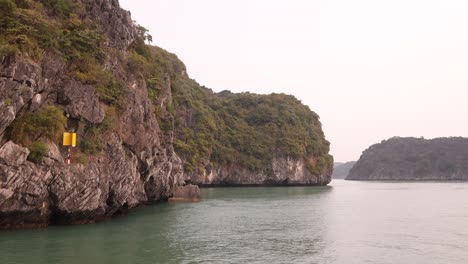 Blick-Auf-Ein-Schiff,-Das-Durch-Schroffe-Kalksteinfelsen-In-Cat-Ba-Und-Der-Halong-Bucht-Im-Norden-Vietnams-Schwimmt