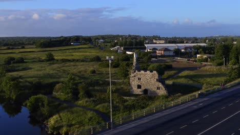 Umkreisen-Sie-Die-Burg-Terryland-Am-Fluss-Corrib-In-Galway,-Irland,-Vorbei-An-Der-Autobahn,-Um-Die-Ruinen-Zu-Sehen