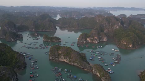 drone-shot-of-fishing-village-tucked-away-in-island-cliffs-in-Cat-Ba-and-Halong-Bay-in-Northern-Vietnam