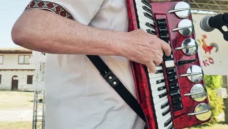 Accordion-musician-at-Bulgarian-Petrovden-folklore-festival,-close-up