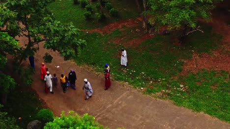 High-angle-view-of-people-dressed-in-traditional-African-clothing-in-a-park-in-Abuja,-Nigeria-welcomed-by-some-drummers-and-greeting-each-other-and-talking