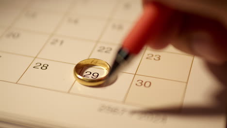 Marking-the-date-on-a-calendar-for-a-wedding-anniversary-and-drawing-a-heart-shape-on-the-day-to-remember-it