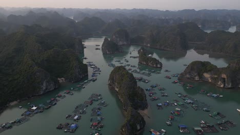 Toma-Aérea-De-Un-Pueblo-Pesquero-Flotante-En-Medio-De-Islas-En-Cat-Ba-Y-La-Bahía-De-Halong-En-El-Norte-De-Vietnam