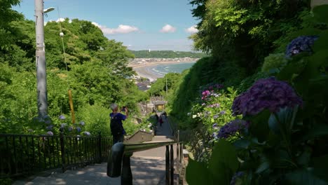 Slow-motion-push-in-view-over-stairs-leading-down-at-shrine-with-ocean-in-background