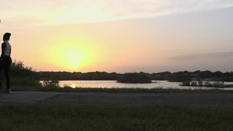 Establishing-shot-of-people-walking-on-path-in-park-for-exercise-as-sun-is-setting