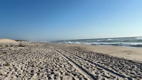 Flauschiger-Sandstrand-Mit-Reifenspuren-Im-Sand-Und-Am-Strand-Brechenden-Wellen