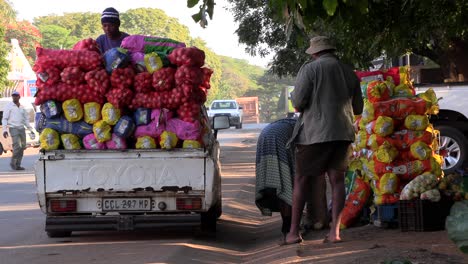 People-at-a-fruit-and-vegetable-market-in-a-busy-street-loading-a-small-pickup-truck