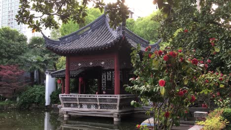 Chinese-pavilion-reflected-in-pond-in-Heping-Park-in-Shanghai,-China-at-sunset,-static-shot