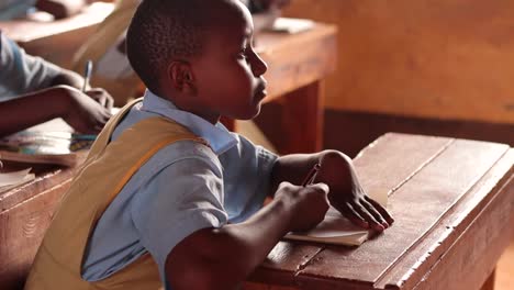 A-young-girl-in-a-class-room-writing-notes-in-her-notebook