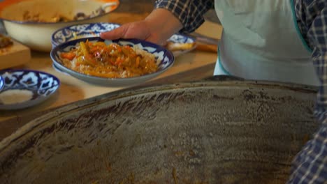 Uzbek-people-in-Samarkand,-Uzbekistan-are-cooking-Uzbek-pilav-or-plov,-a-national-dish-of-Uzbekistan-and-a-rice-dish-common-for-people-of-Central-Asia