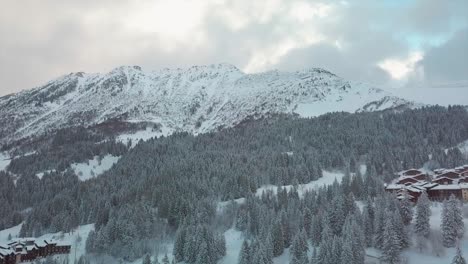 Vista-{aérea}-De-Un-Dron-Sobre-Una-Estación-De-Esquí-Nevada-Francesa-Durante-El-Invierno