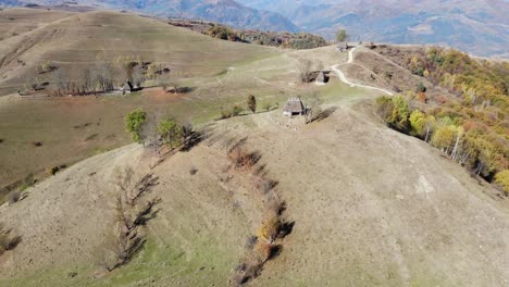 Rumänisches-Abgelegenes-Dorf-Mit-Traditionellen-Strohgedeckten-Häusern-Auf-Den-Hügeln,-Herbstlandschaft