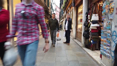 People-walking-through-crowded-streets-of-Venice,-camera-dolly-through-crowd